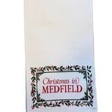 White kitchen towel with 'Christmas in Medfield' text on a white background. Available at Be Charmed.