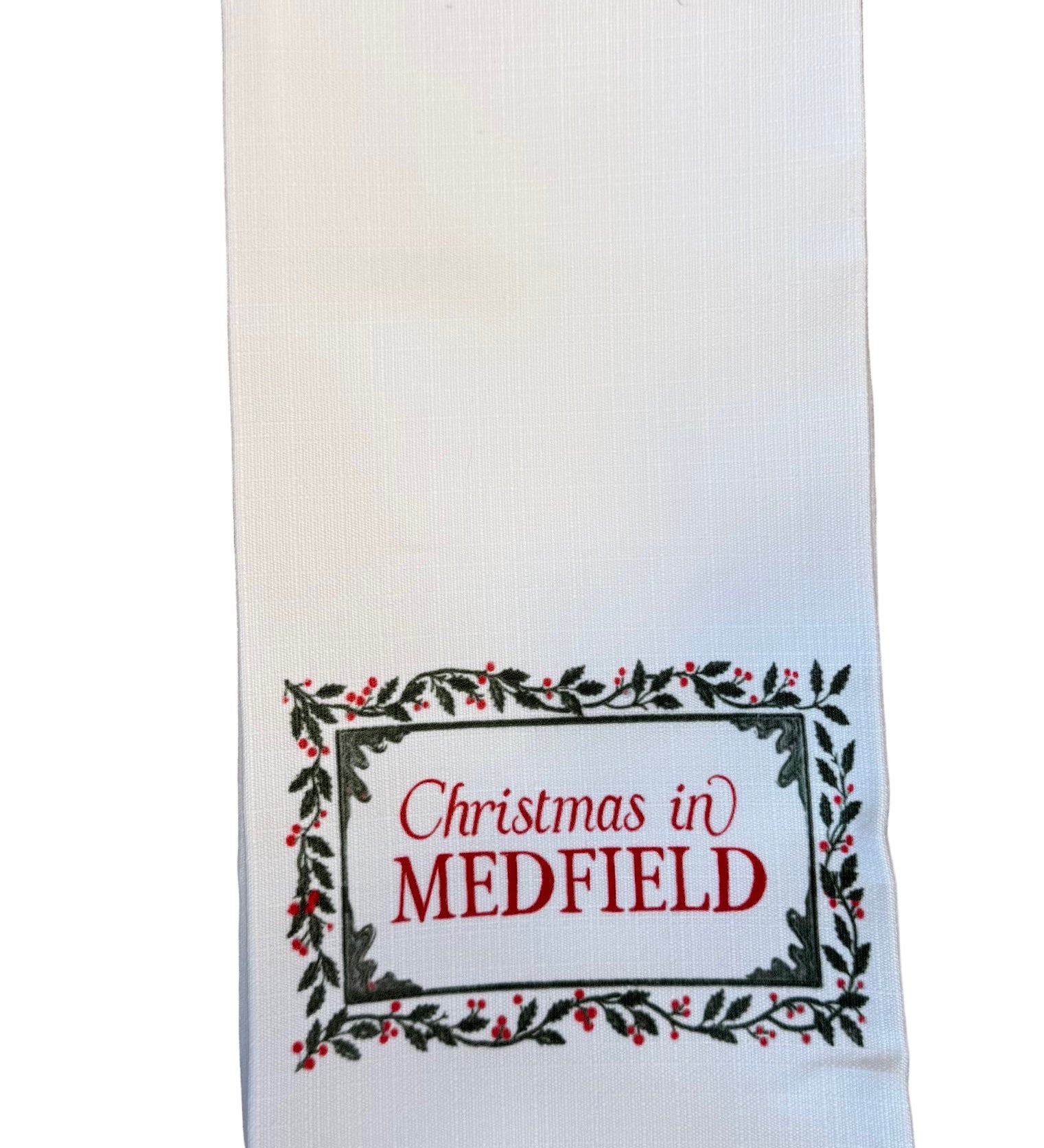 White kitchen towel with 'Christmas in Medfield' text on a white background. Available at Be Charmed.