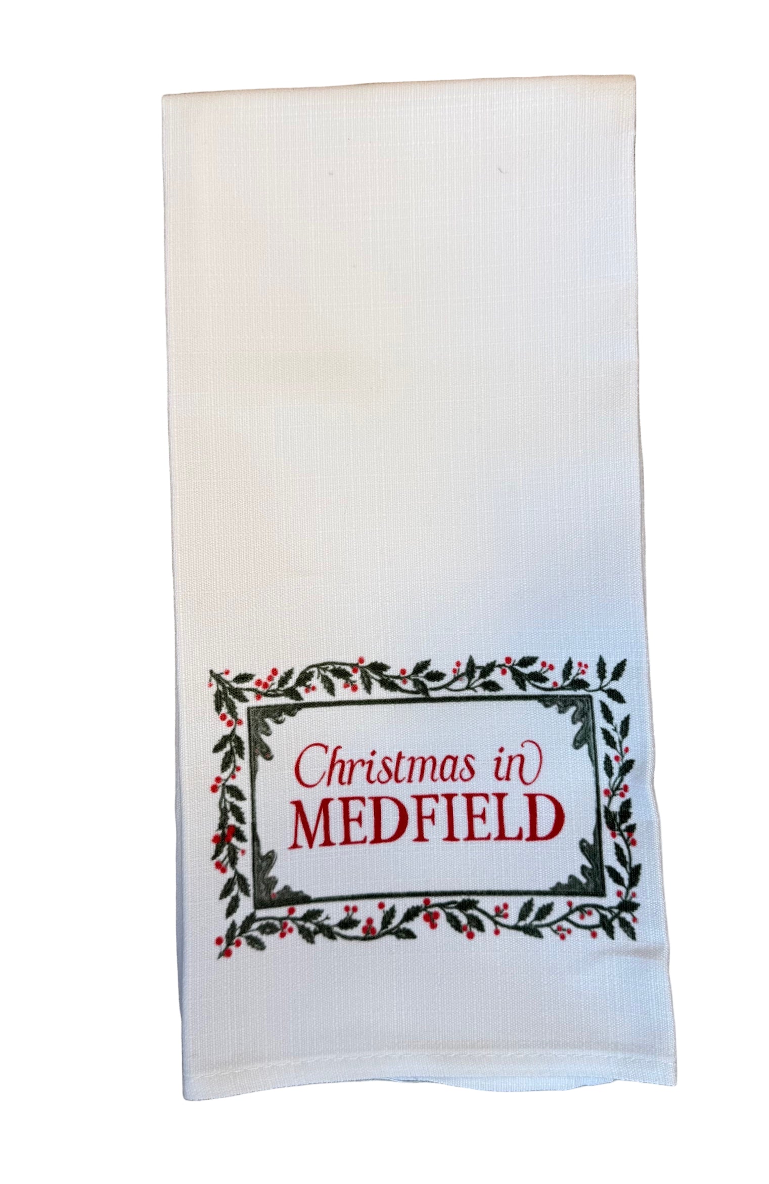 White kitchen towel with 'Christmas in Medfield' text on a white background. Available at Be Charmed.