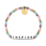 Little Words Project Dream in Color Inspire Bracelet – Colorful beaded bracelet with white letter beads spelling "INSPIRE," available at Be Charmed.