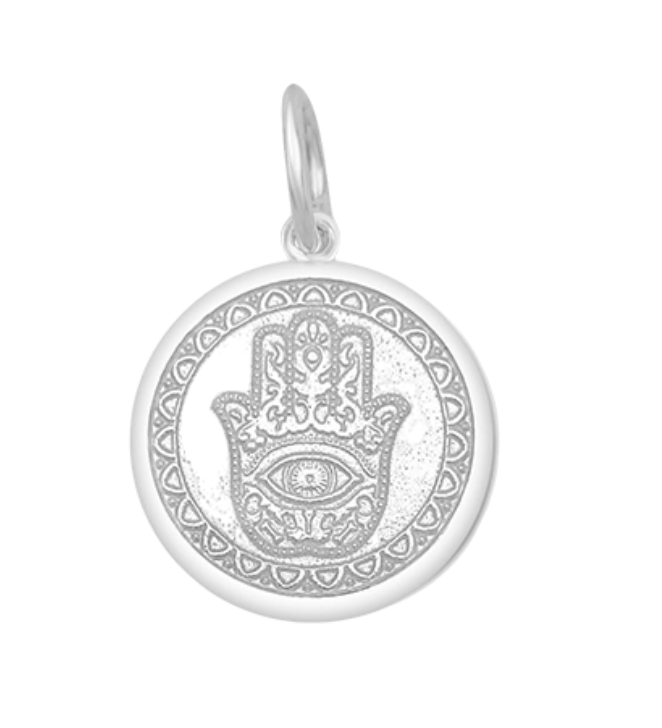 A Lola sterling silver pendant with an alpine white center featuring the Hamsa Hand, with enamel inlay. Available at Be Charmed