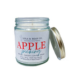 Candle jar labeled 'Apple Picking' by Lola & Bean Co. on a white background. Available at Be Charmed. 
