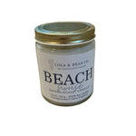 Lola & Bean Beach House 7.5 oz Soy Candle – White glass jar with wooden lid, featuring a coastal-inspired scent, available at Be Charmed.