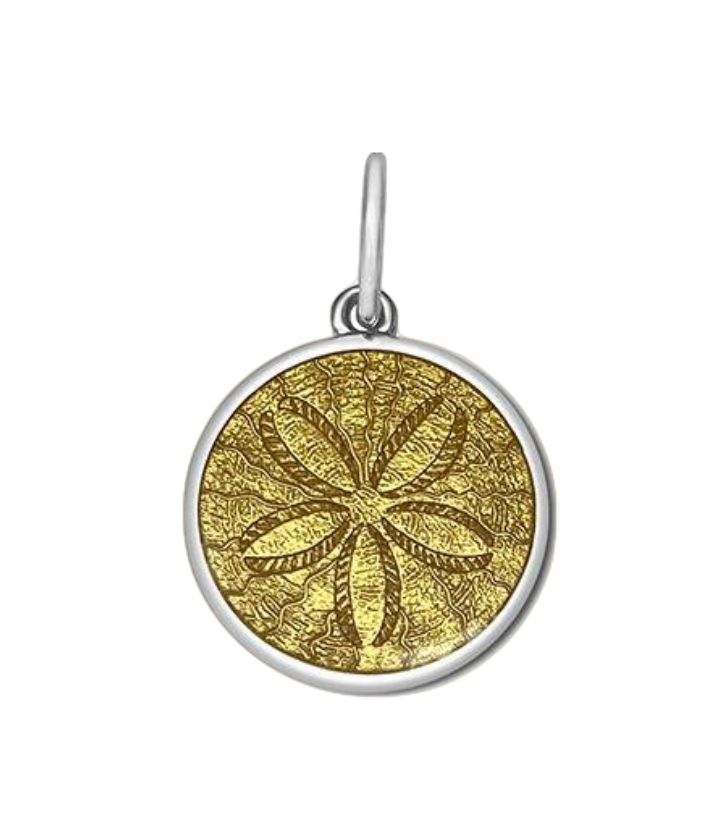 A sterling silver pendant with a gold vermeil center, featuring an engraved design resembling a sand dollar. Available at Be Charmed