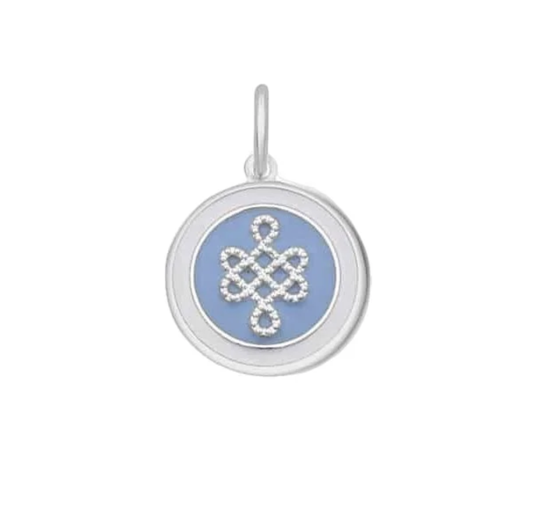 A round sterling silver pendant charm featuring a lavender enamel center with a silver Celtic knot design, shown on a plain white background. Available at Be Charmed