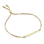 Lucky Feather Bestie Morse Code Bracelet featuring a gold-dipped bar engraved with 'Bestie' in Morse code, on an adjustable cord. Available at Be Charmed.