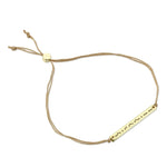 Lucky Feather Fearless Morse Code Bracelet featuring a gold-dipped bar engraved with 'Fearless' in Morse code, on an adjustable cord. Available at Be Charmed.