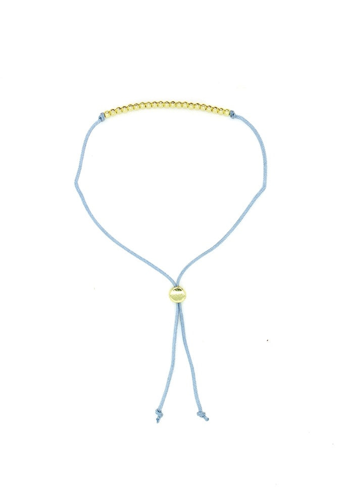 Lucky Feather Fun Twenty-One Milestone Birthday Bracelet featuring 21 gold-dipped beads on an adjustable cord, symbolizing each year. Available at Be Charmed.