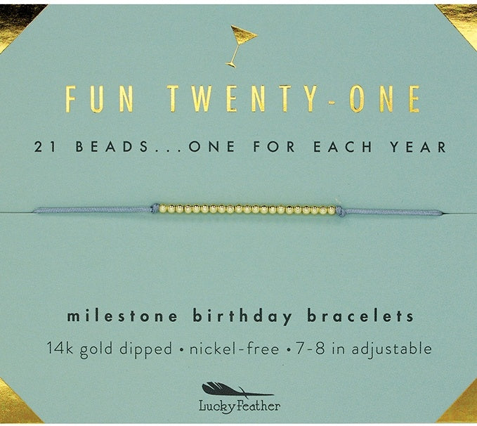 Lucky Feather Fun Twenty-One Milestone Birthday Bracelet on card featuring 21 gold-dipped beads on an adjustable cord, symbolizing each year. Available at Be Charmed.