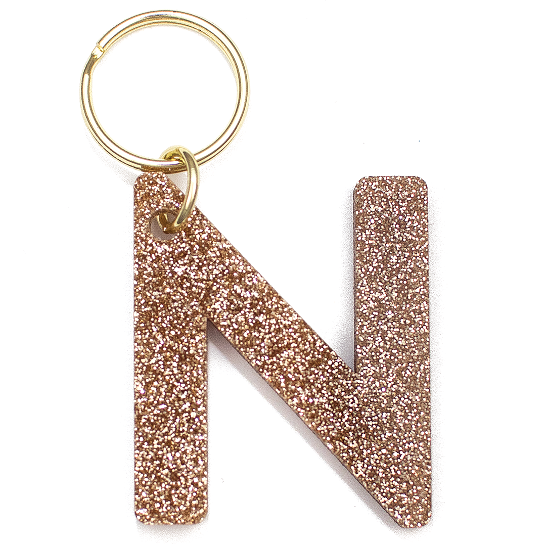 Lucky Feather Initial N Keychain featuring glittery acrylic letter charm with gold-tone hardware, personalized for each letter. Available at Be Charmed.