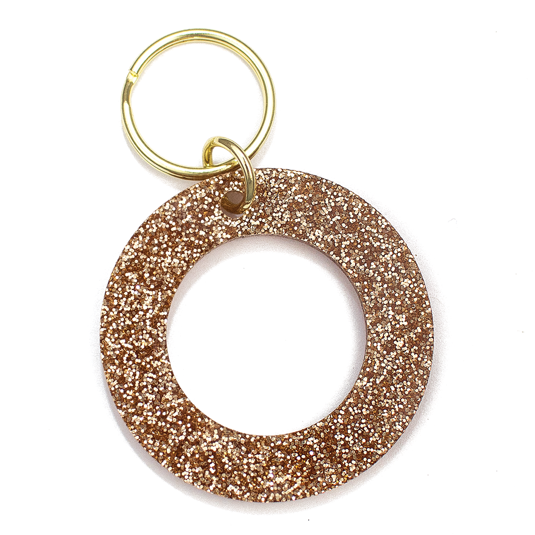 Lucky Feather Initial O Keychain featuring glittery acrylic letter charm with gold-tone hardware, personalized for each letter. Available at Be Charmed.