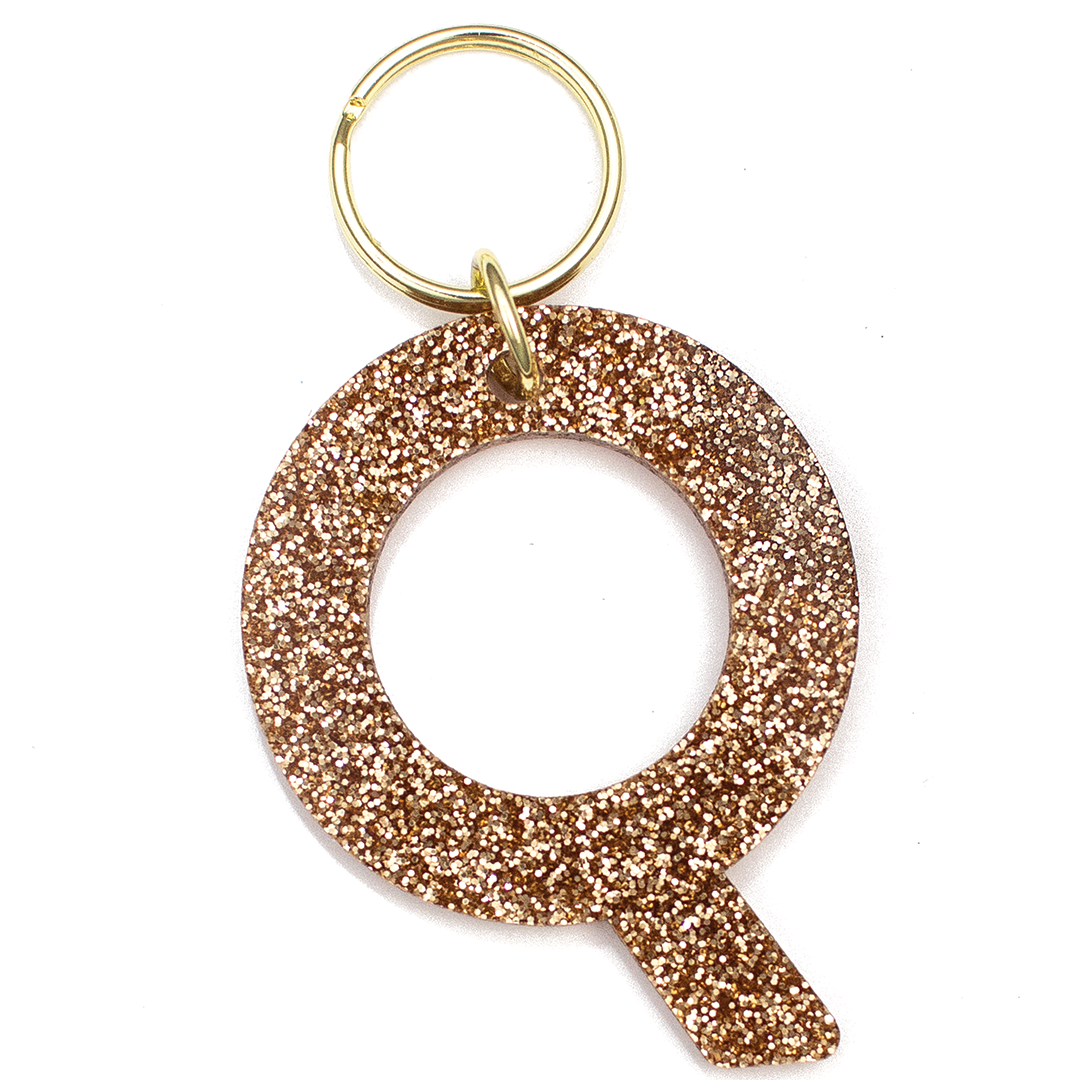 Lucky Feather Initial Q Keychain featuring glittery acrylic letter charm with gold-tone hardware, personalized for each letter. Available at Be Charmed.