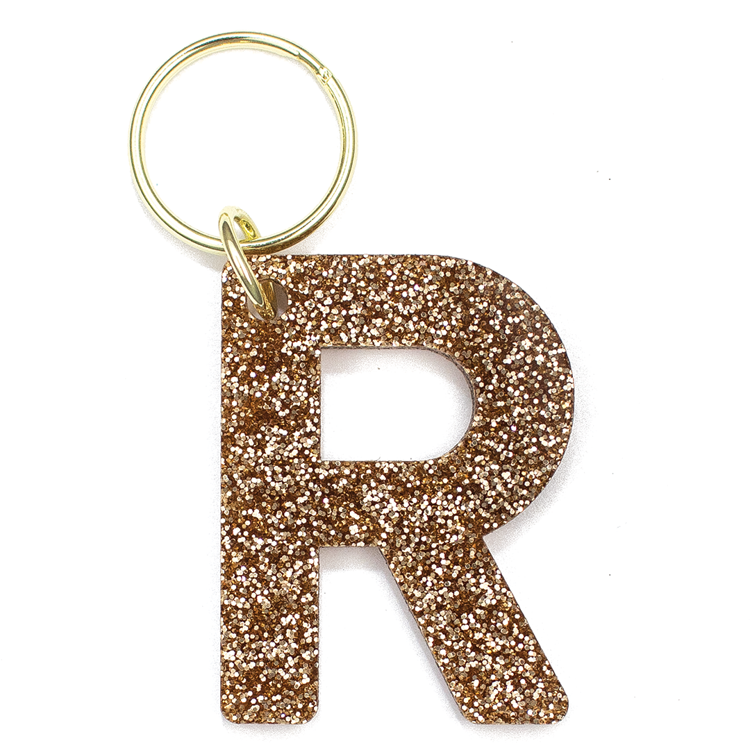 Lucky Feather Initial R Keychain featuring glittery acrylic letter charm with gold-tone hardware, personalized for each letter. Available at Be Charmed.