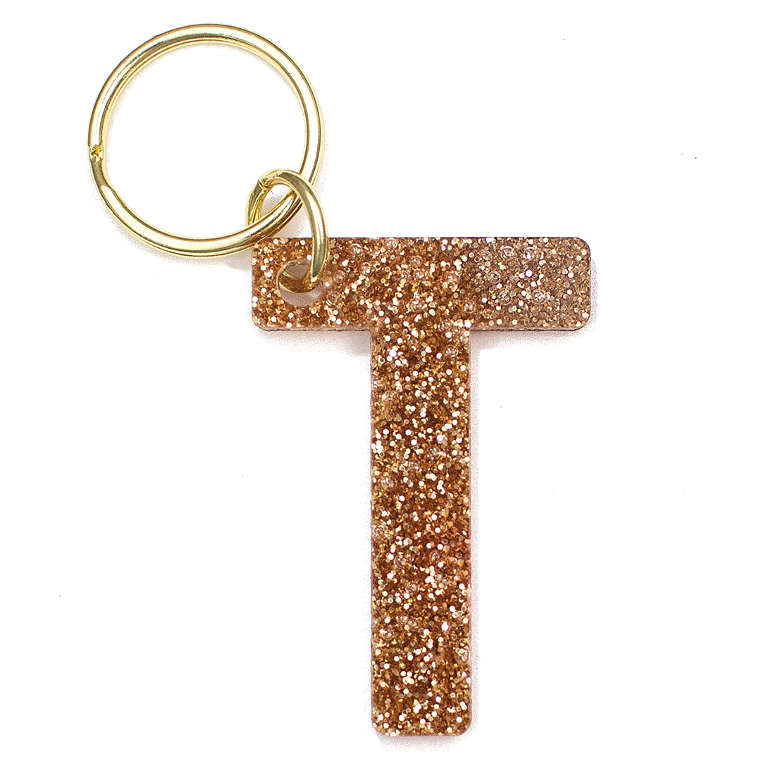 Lucky Feather Initial T Keychain featuring glittery acrylic letter charm with gold-tone hardware, personalized for each letter. Available at Be Charmed.