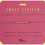 Lucky Feather Sweet Sixteen Milestone Birthday Bracelet on card featuring 16 gold-dipped beads on an adjustable cord, symbolizing each year. Available at Be Charmed.