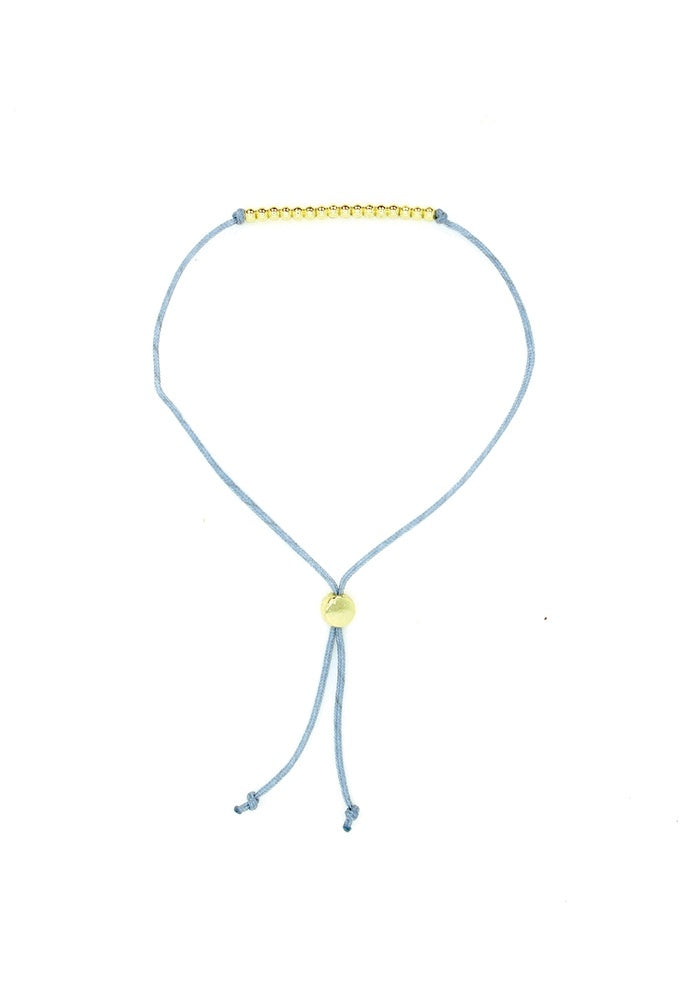Lucky Feather Sweet Sixteen Milestone Birthday Bracelet featuring 16 gold-dipped beads on an adjustable cord, symbolizing each year. Available at Be Charmed.