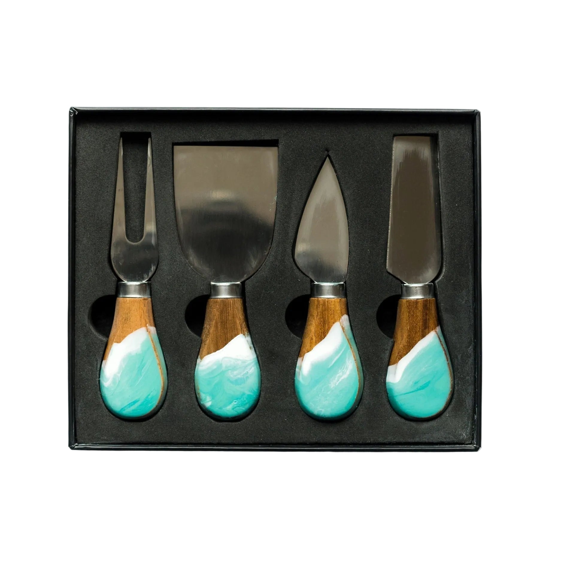Set of four cheese knives with turquoise handles in a black box on a white background. Available at Be Charmed