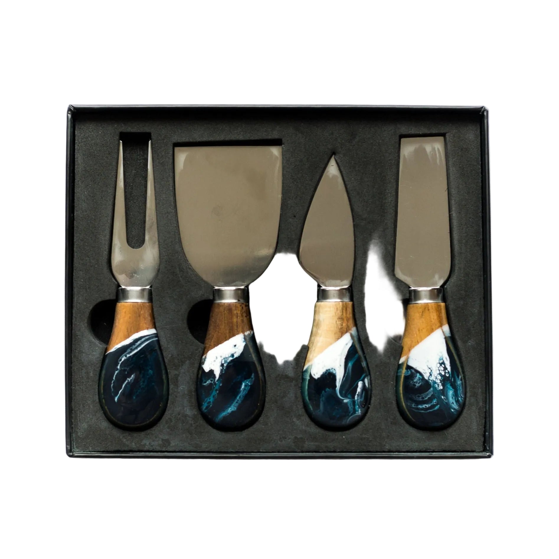 Set of four cheese knives with decorative handles in a black box on a white background. Available at Be Charmed