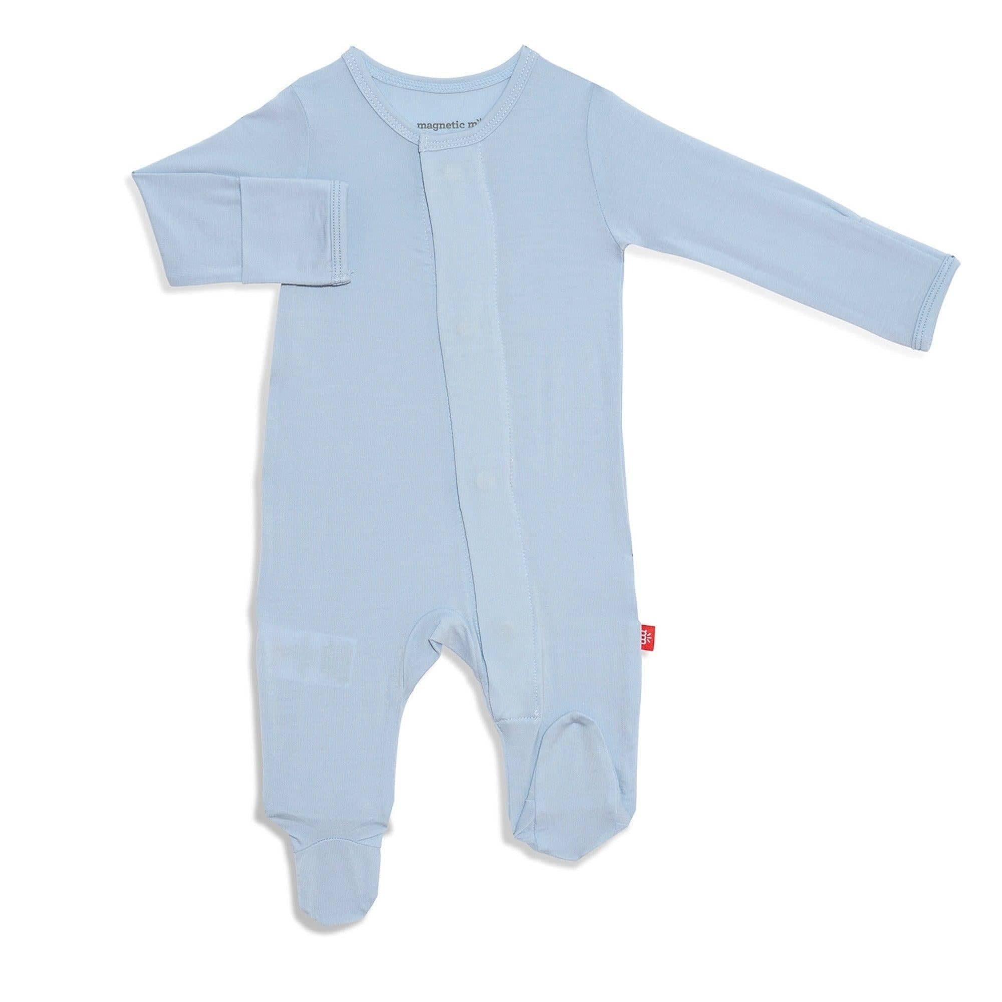 A baby blue magnetic me footie with a V-neckline, long sleeves, and a snug fit design, featuring magnetic closures and a brand tag on the lower left side. Available at Be Charmed