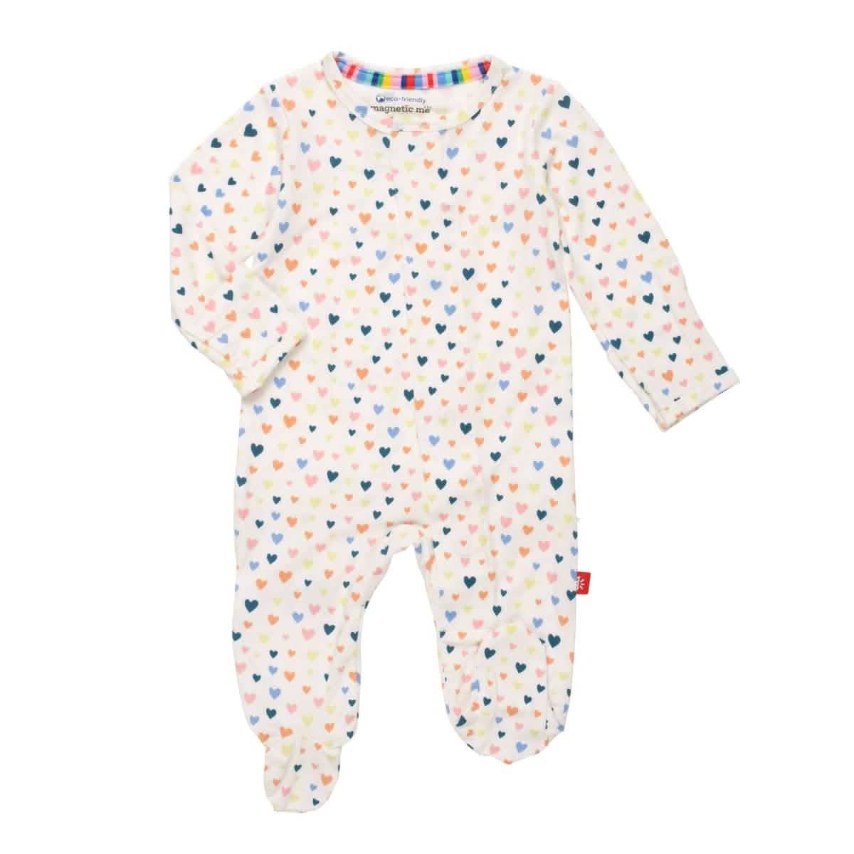 A multicolored baby Magnetic Me footie with a heart pattern and magnetic closures, laid flat. Available at Be Charmed