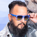 Man wearing Goodr Jellyfishing For Compliments Sunglasses with vibrant blue frames and  polarized lenses, designed for active comfort and bold beachy style, available at Be Charmed