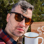 Man wearing Goodr Nine Dollar Pour Over Sunglasses with rich coffee-brown frames and polarized lenses, inspired by premium brews and built for performance, available at Be Charmed