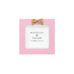 Pink photo frame with gold bow and 'Mariposa' branding on a white background. Available at Be Charmed. 
