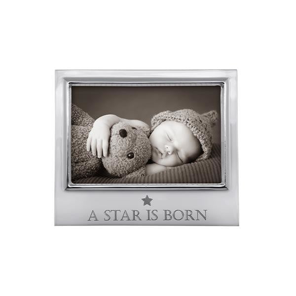 A silver-colored aluminum picture frame with a photo of a baby and a teddy bear, and the text 'A Star Is Born' on the bottom right. Available at Be Charmed