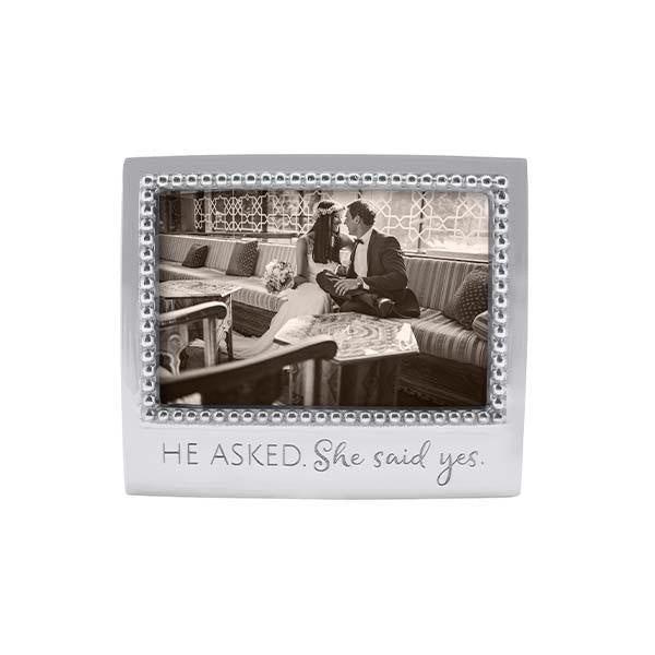 A 4x6 beaded picture frame with an engraved quote 'He asked. She said Yes.' Available at Be Charmed