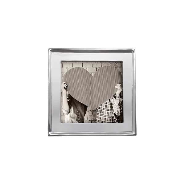 A 4x4 Mariposa picture frame made of recycled aluminum with a photograph of a couple holding a heart-shaped mirror. Available at Be Charmed