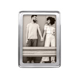 A recycled aluminum 5x7 Mariposa picture frame with a transparent front, displaying an image of two people standing close by a wall. Available at Be Charmed