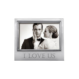 A 4x6 picture frame with a silver border, displaying an image of a couple and the text 'I love us'. Available at Be Charmed