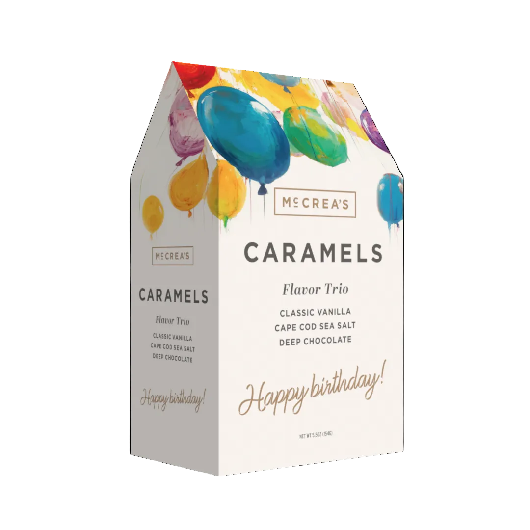 Box of McCrea's Caramels with colorful balloons on a white background. Available at Be Charmed