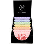 Display box of McCrea's Love & Caramels with colorful candy packages. Available at Be Charmed