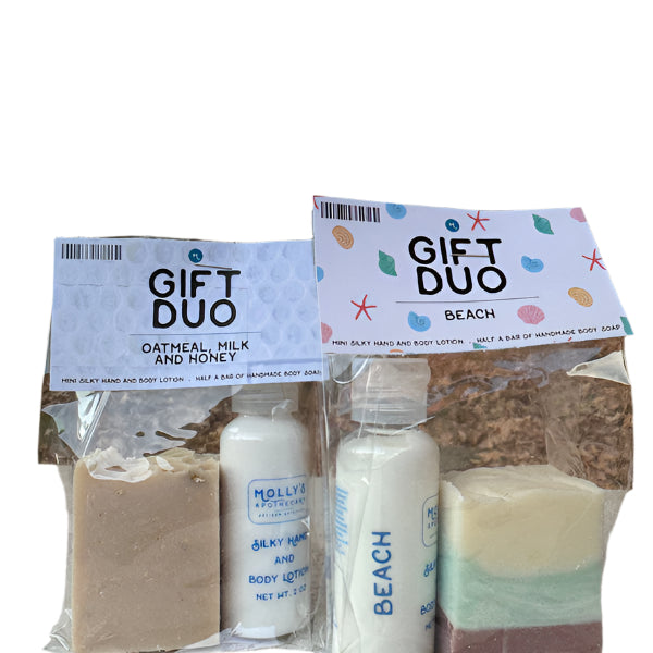 A gift duo set from Molly's Apothecary, including a bar of soap and a bottle of lotion, packaged in a clear plastic bag with a printed label that says 'GIFT DUO' and 'DATHEAL PICKLING RECIPE'. The products are visible through the transparent packaging. Available at Be Charmed