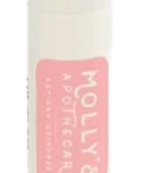 A white lip balm stick with a pink label that reads 'Molly's Apothecary - Creamy'. Available at Be Charmed