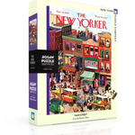 A puzzle box cover featuring a colorful illustration of a bustling Main Street scene with pedestrians and storefronts, titled 'The New Yorker'. Available at Be Charmed