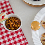 Nora Fleming Baggin' Rights Mini Charm  on serving bowl – Hand-painted ceramic pretzel accent for serveware, available at Be Charmed