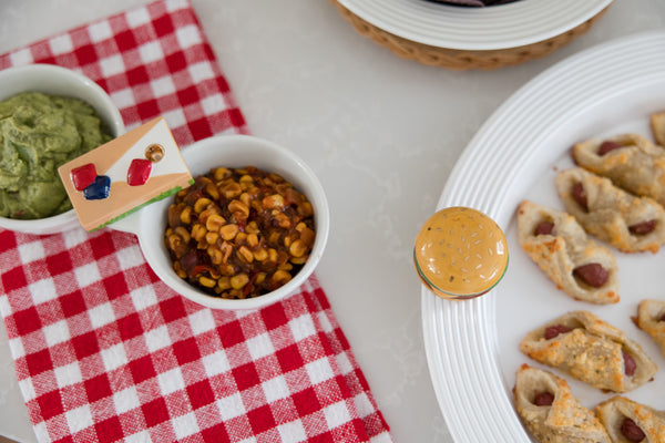 Nora Fleming Baggin' Rights Mini Charm  on serving bowl – Hand-painted ceramic pretzel accent for serveware, available at Be Charmed