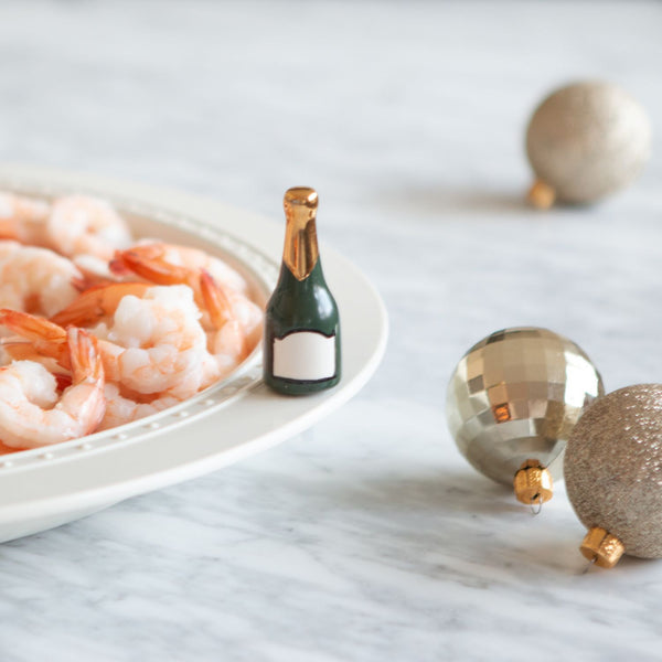 Nora Fleming "Champagne Celebration" Mini Charm on platter – Hand-painted ceramic champagne bottle accent for serveware, available at Be Charmed