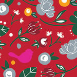 A patterned cocktail napkin featuring a red background with a variety of designs including flowers, leaves, a bird, and abstract shapes. Available at Be Charmed