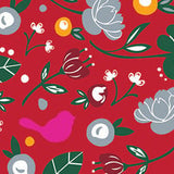 A patterned cocktail napkin featuring a red background with a variety of designs including flowers, leaves, a bird, and abstract shapes. Available at Be Charmed