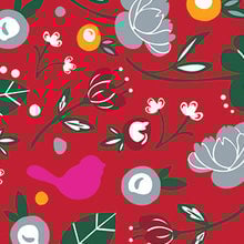 A patterned cocktail napkin featuring a red background with a variety of designs including flowers, leaves, a bird, and abstract shapes. Available at Be Charmed