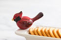 Nora Fleming Winter Songbird Mini ceramic accessory on dish, a festive winter and holiday serveware accent. Available at Be Charmed.