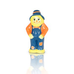 A ceramic mini figurine of a smiling scarecrow in blue overalls with orange and white details. Available at Be Charmed
