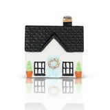 A house-shaped Nora Fleming Charm with a black roof, white front door, and decorative details. Available at Be Charmed