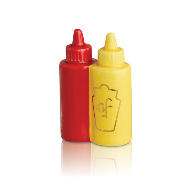 A set of two mini condiment bottles, one red and one yellow, each with a gold 'NF' emblem. Available at Be Charmed
