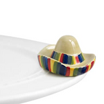 A multicolored striped mini sombrero-shaped dish charm on a white plate. Available at Be Charmed