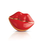 A red and gold colored Nora Fleming mini charm in the shape of a stylized lip. Available at Be Charmed