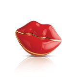 A red and gold colored Nora Fleming mini charm in the shape of a stylized lip. Available at Be Charmed